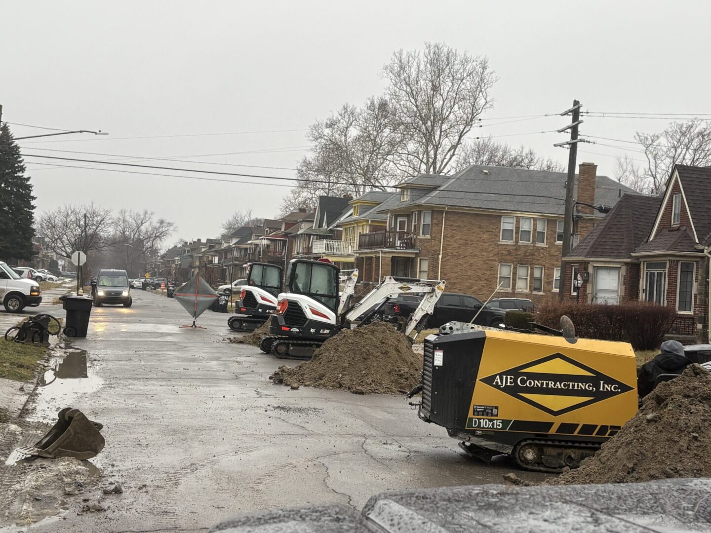 Construction site on a residential street with equipment and materials.