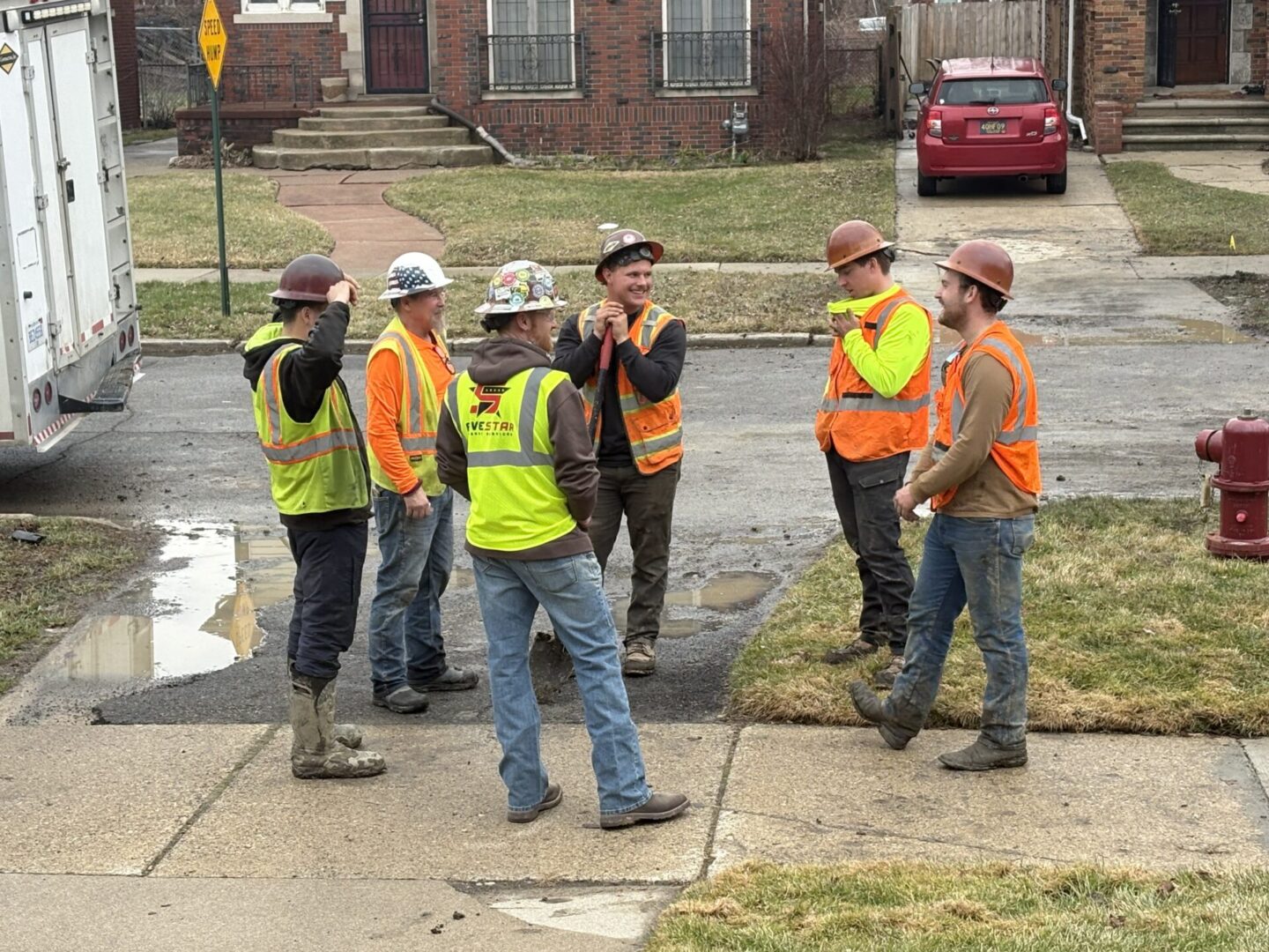 Group of construction workers wearing safety vests and helmets.
