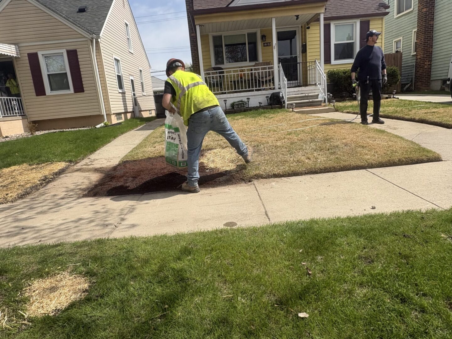 Workers laying sod in a residential yard.