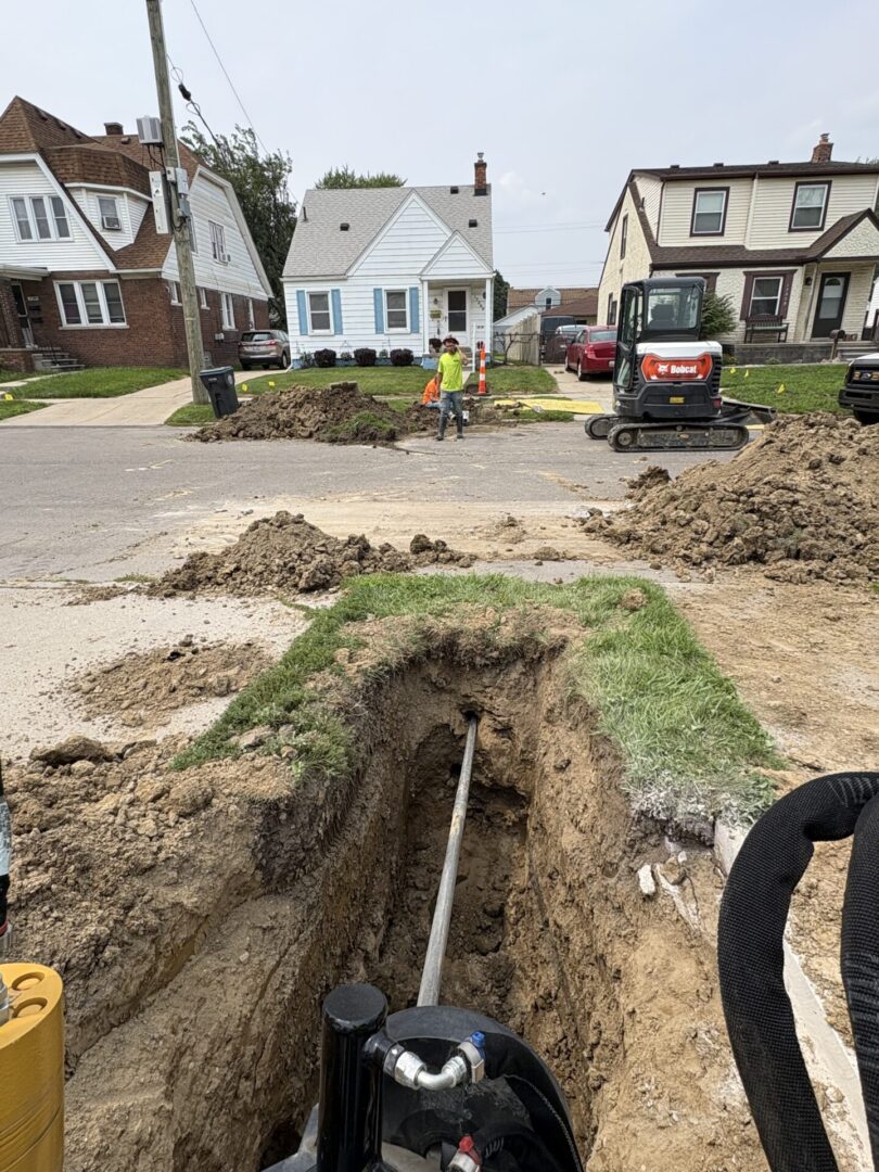 Workers install underground pipes in a residential area.