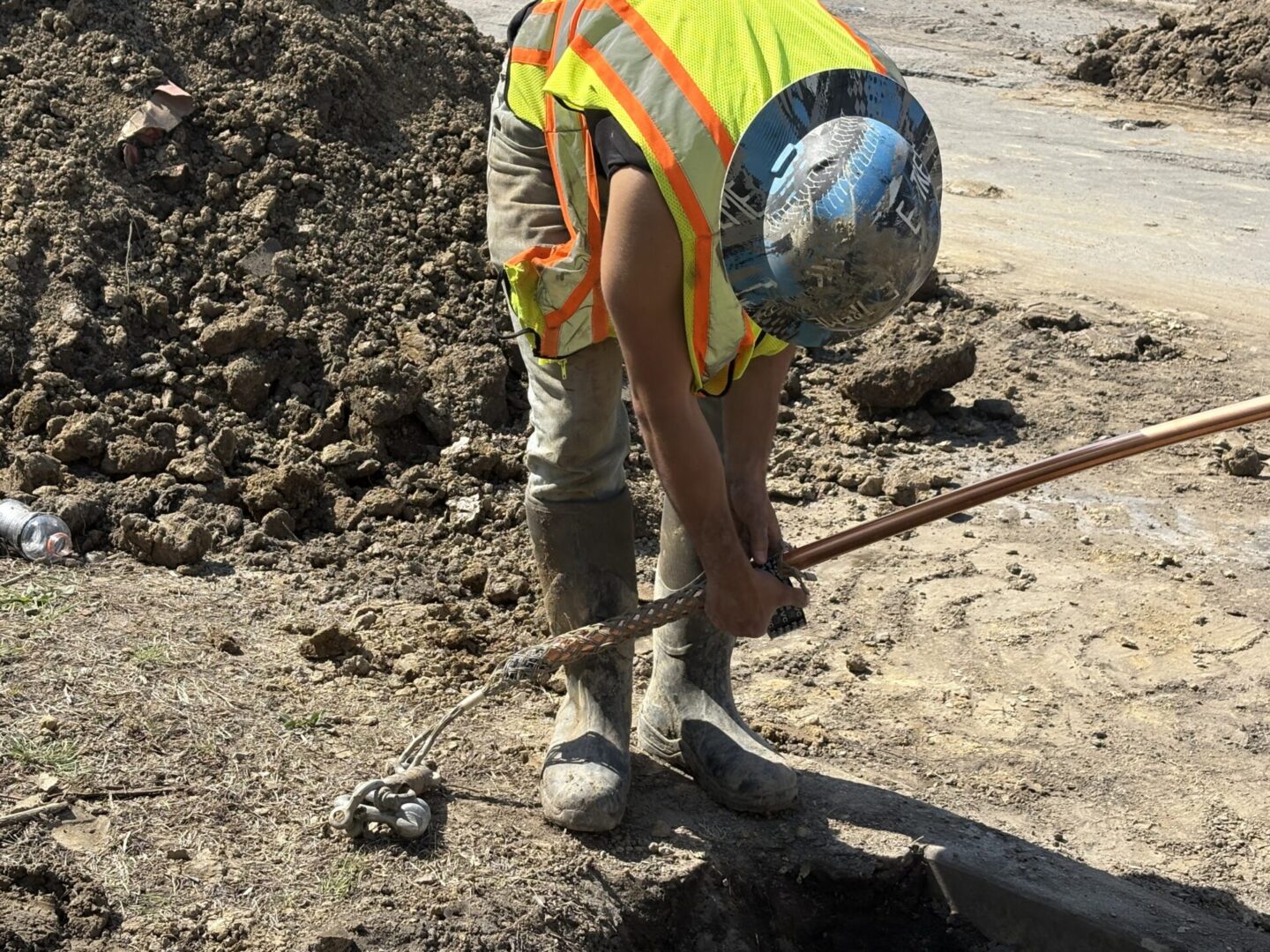 Construction worker shoveling dirt at a work site.