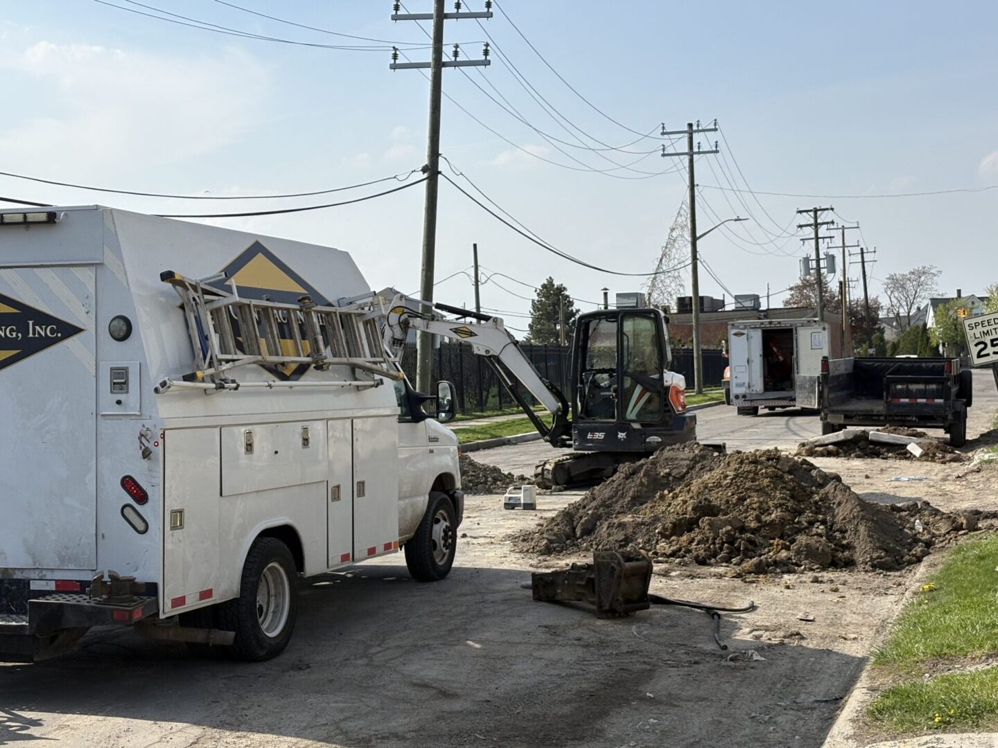 Utility workers repairing a road with trucks and excavators.