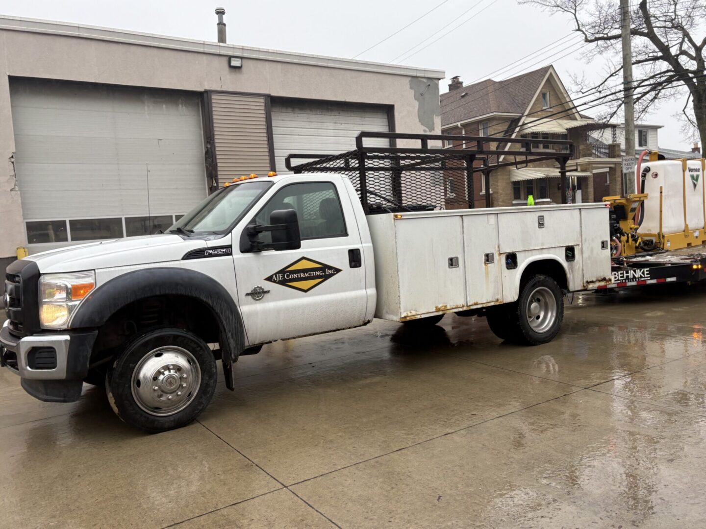 White utility truck parked on wet pavement