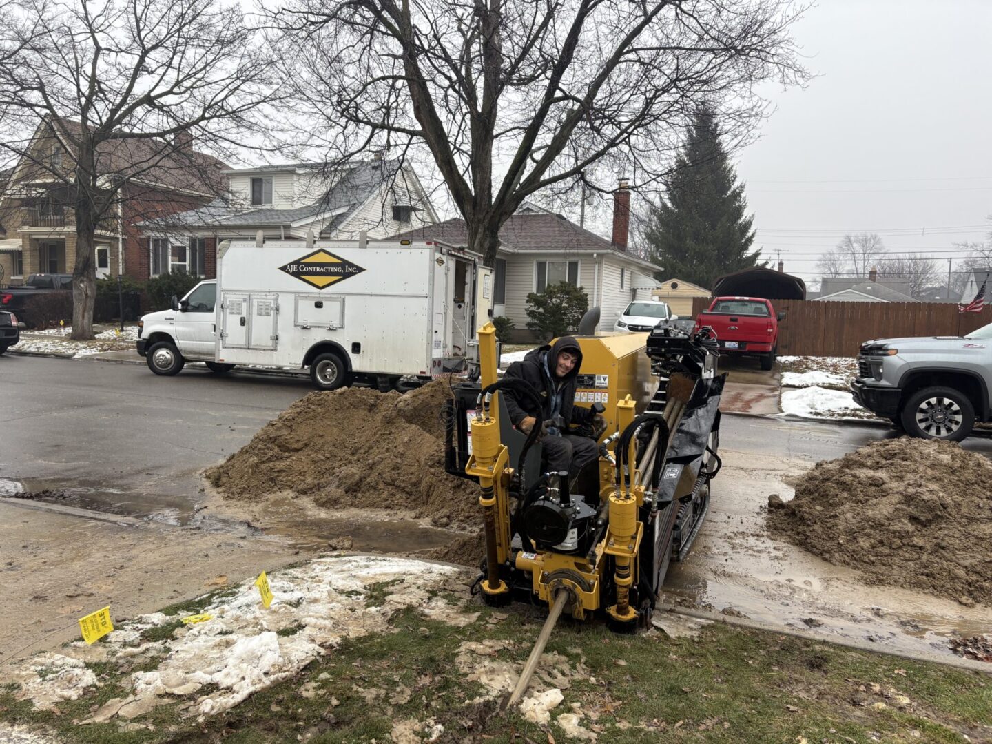 Worker operating yellow drilling machine on street