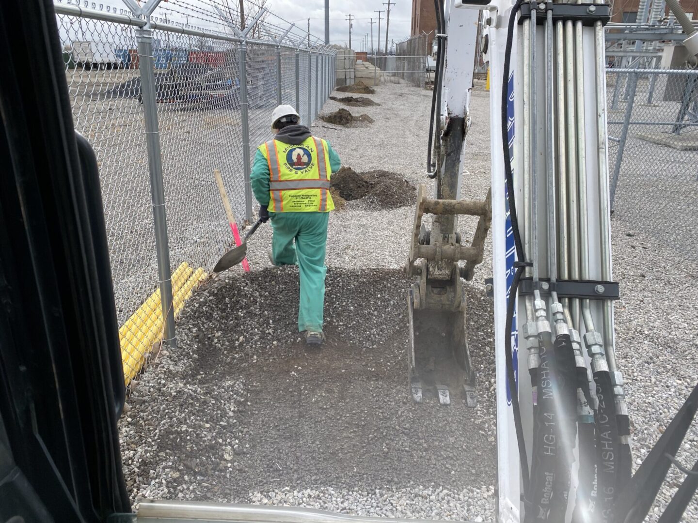 Worker pouring concrete through a chute at a construction site.